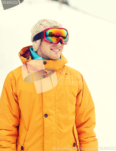 Image of happy young man in ski goggles outdoors