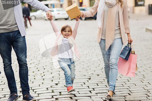 Image of happy family with child and shopping bags in city