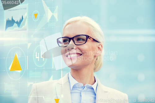 Image of young smiling businesswoman in eyeglasses outdoors