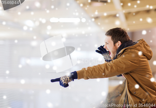 Image of young man supporting hockey game on skating rink