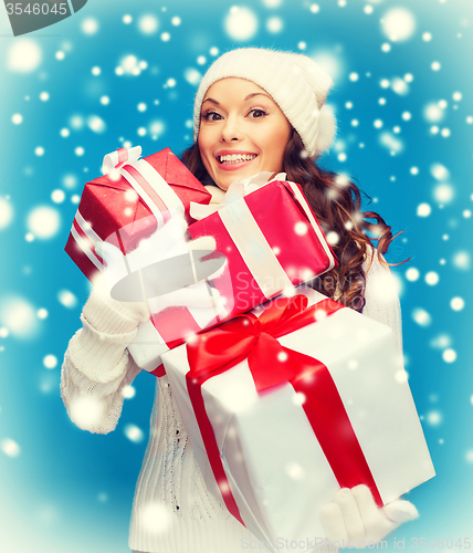 Image of woman in sweater and hat with many gift boxes