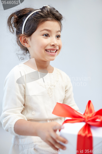 Image of happy little girl with gift box at home