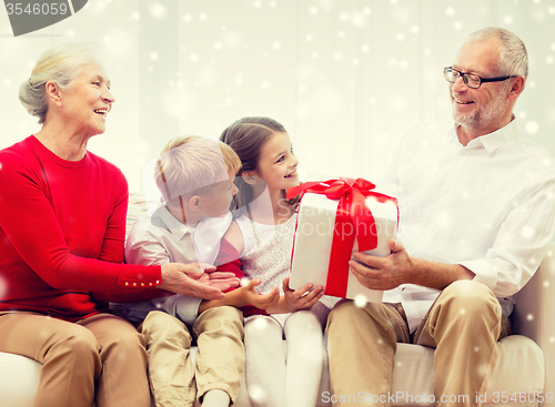 Image of smiling grandparents and grandchildren with gift