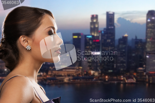 Image of woman with diamond earring over night city