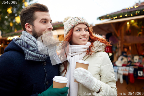 Image of happy couple drinking coffee on old town street