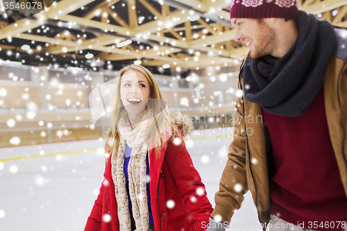 Image of happy couple holding hands on skating rink