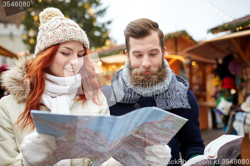 Image of happy couple with map and city guide in old town