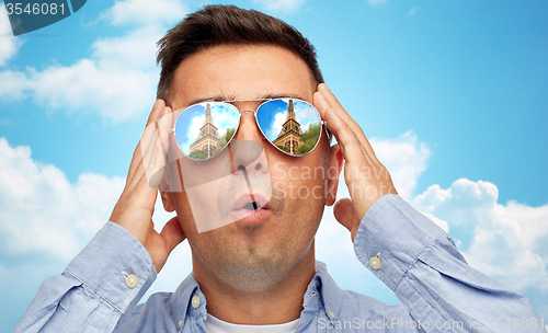 Image of face of man in sunglasses looking at eiffel tower