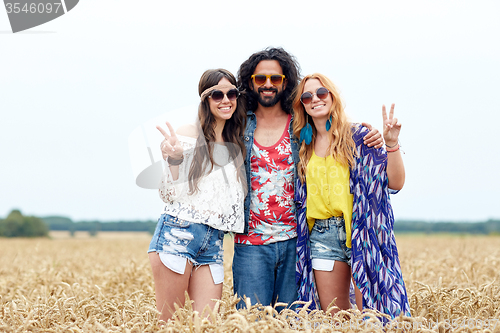 Image of happy young hippie friends showing peace outdoors