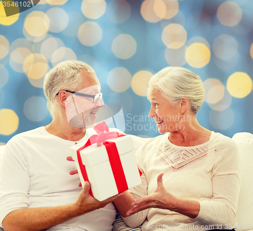 Image of happy senior couple with gift box