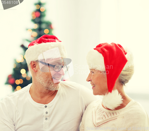 Image of happy senior couple in santa helper hats