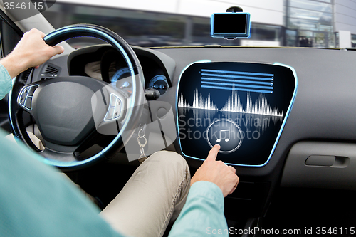 Image of close up of man driving car with audio system