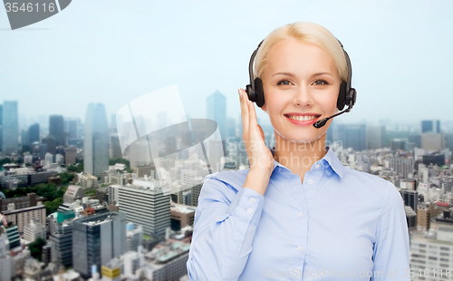 Image of helpline operator in headset over city background