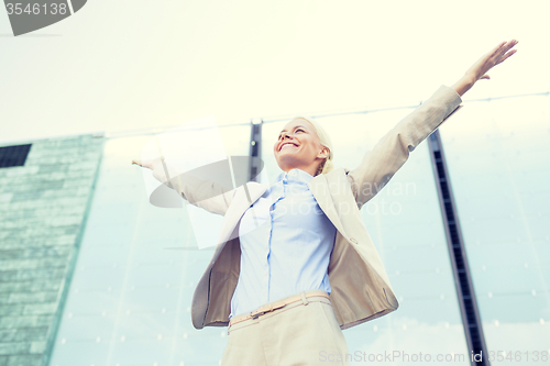 Image of young smiling businesswoman over office building