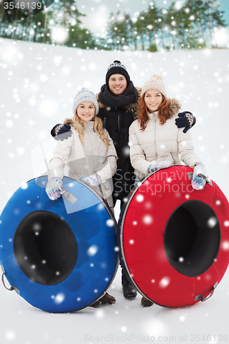 Image of group of smiling friends with snow tubes