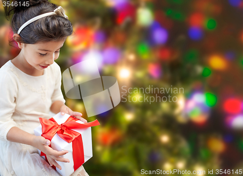 Image of happy little girl with present over lights