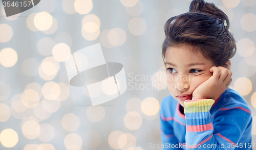 Image of sad little girl over holidays lights background