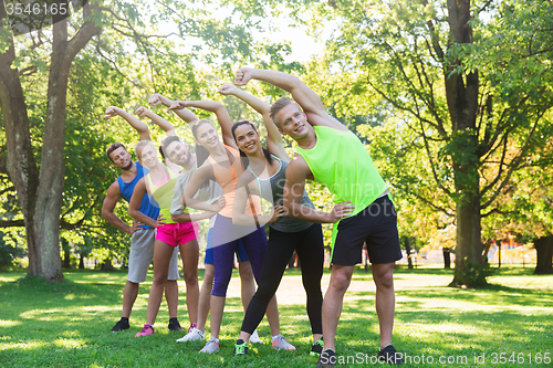 Image of group of friends or sportsmen exercising outdoors