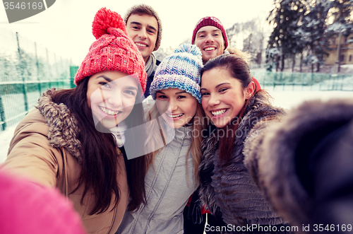 Image of happy friends taking selfie with smartphone