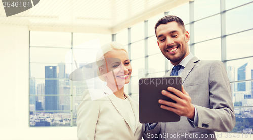 Image of smiling businessmen with tablet pc outdoors