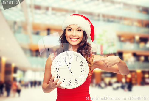 Image of smiling woman in santa helper hat with clock