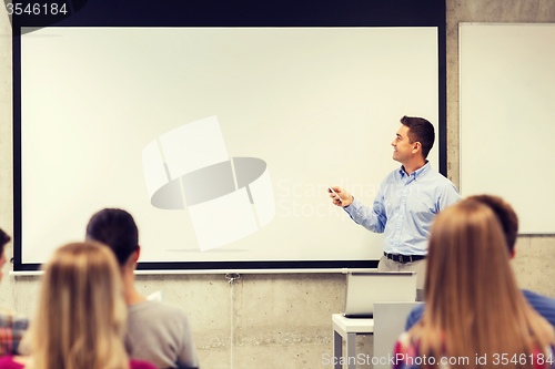 Image of group of students and smiling teacher in classroom