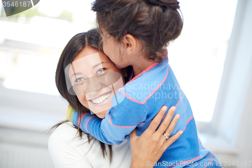 Image of happy mother and daughter hugging at home