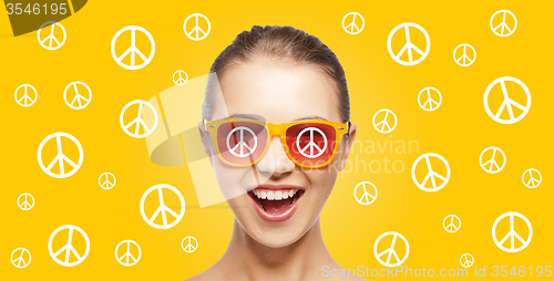 Image of happy teenage hippy girl in shades with peace sign