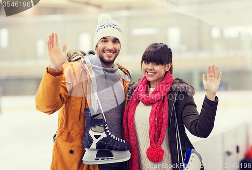 Image of happy couple with ice-skates on skating rink