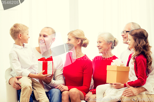Image of smiling family with gifts at home