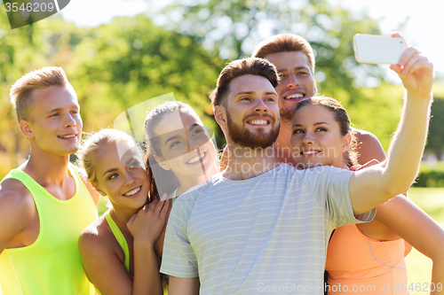 Image of happy friends taking selfie with smartphone