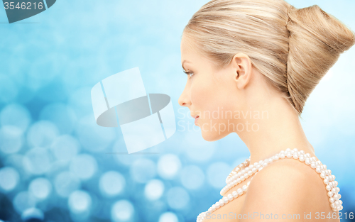 Image of beautiful woman with sea pearl necklace over blue