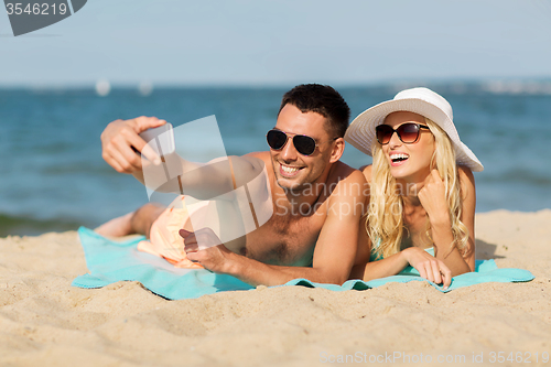 Image of happy couple in swimwear walking on summer beach