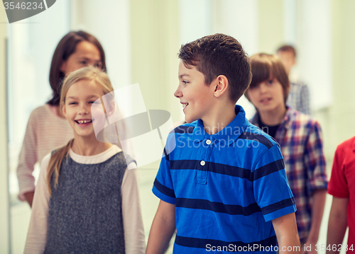 Image of group of smiling school kids walking in corridor