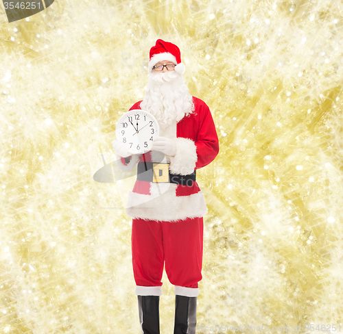 Image of man in costume of santa claus with clock