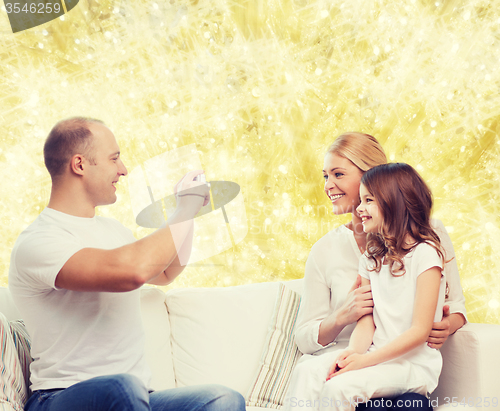 Image of happy family with camera at home
