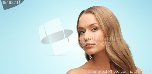 Image of beautiful young woman face over blue background