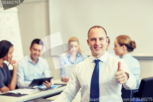 Image of group of smiling businesspeople meeting in office