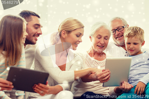 Image of smiling family with tablet pc computers at home