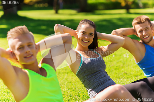 Image of group of friends or sportsmen exercising outdoors