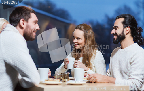 Image of happy friends meeting and drinking tea or coffee