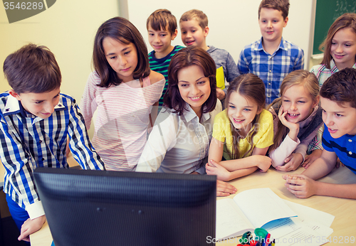 Image of group of kids with teacher and computer at school