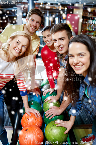 Image of happy friends in bowling club at winter season