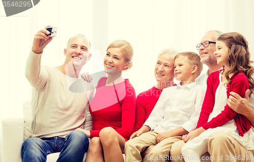 Image of smiling family with camera at home