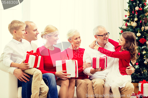 Image of smiling family with gifts at home