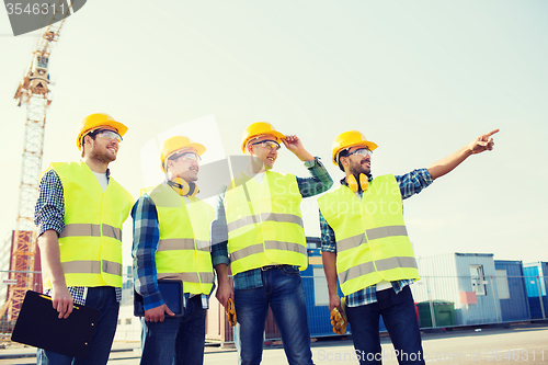 Image of group of smiling builders with tablet pc outdoors