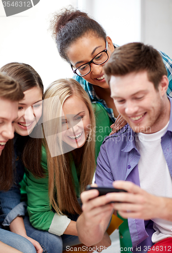 Image of group of happy students with smartphone at school