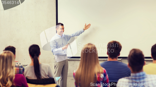 Image of group of students and smiling teacher with notepad