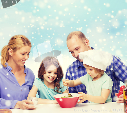 Image of happy family with two kids making salad at home