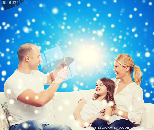 Image of happy family with camera at home